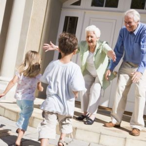 grandparents greeting their grandkids at their home in retirement