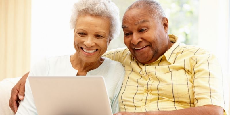 Couple smiling at laptop