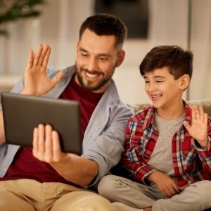 Father and son wave at FaceTime video
