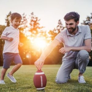 Dad playing football with his son