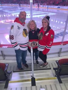 Irene, her husband, and daughter at a Chicago Blackhawks game