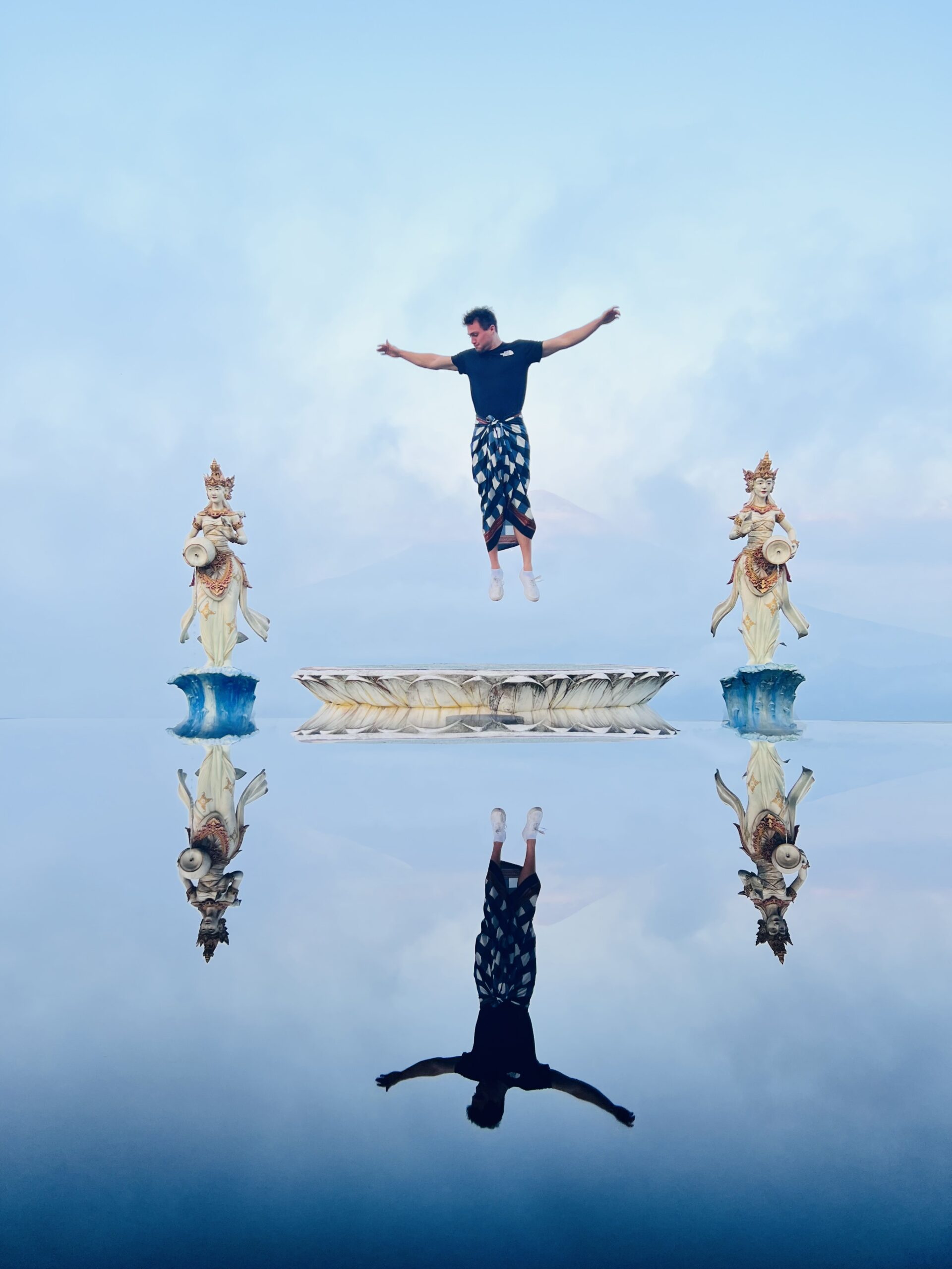 Jumping in air with reflection in water – Bali, Indonesia