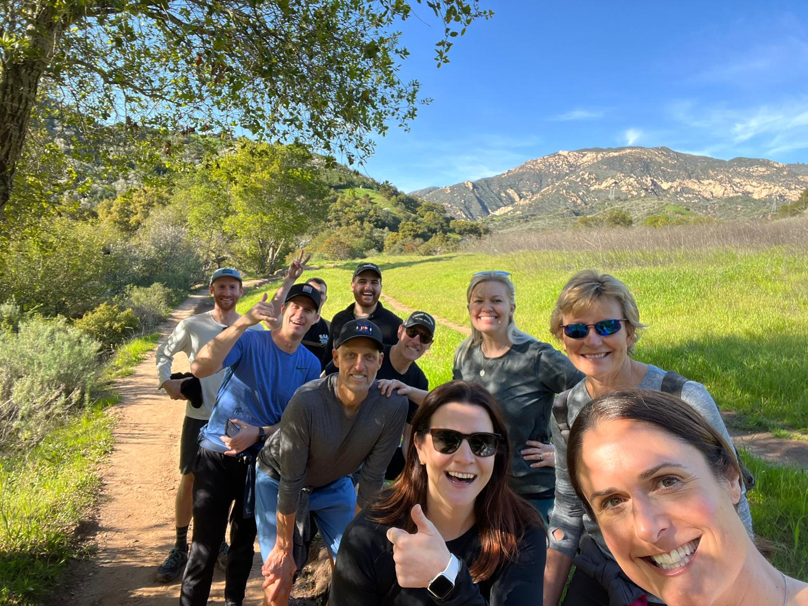 Dannell takes a group selfie with Mission Wealth colleagues during a scenic mountain hike.
