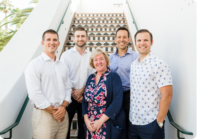 Team members of Diane Williamson Mission Wealth pose together on a staircase, showcasing collaboration and professionalism.