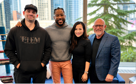 Four professionals pose together in a bright setting, showcasing collaboration and networking in a modern environment.