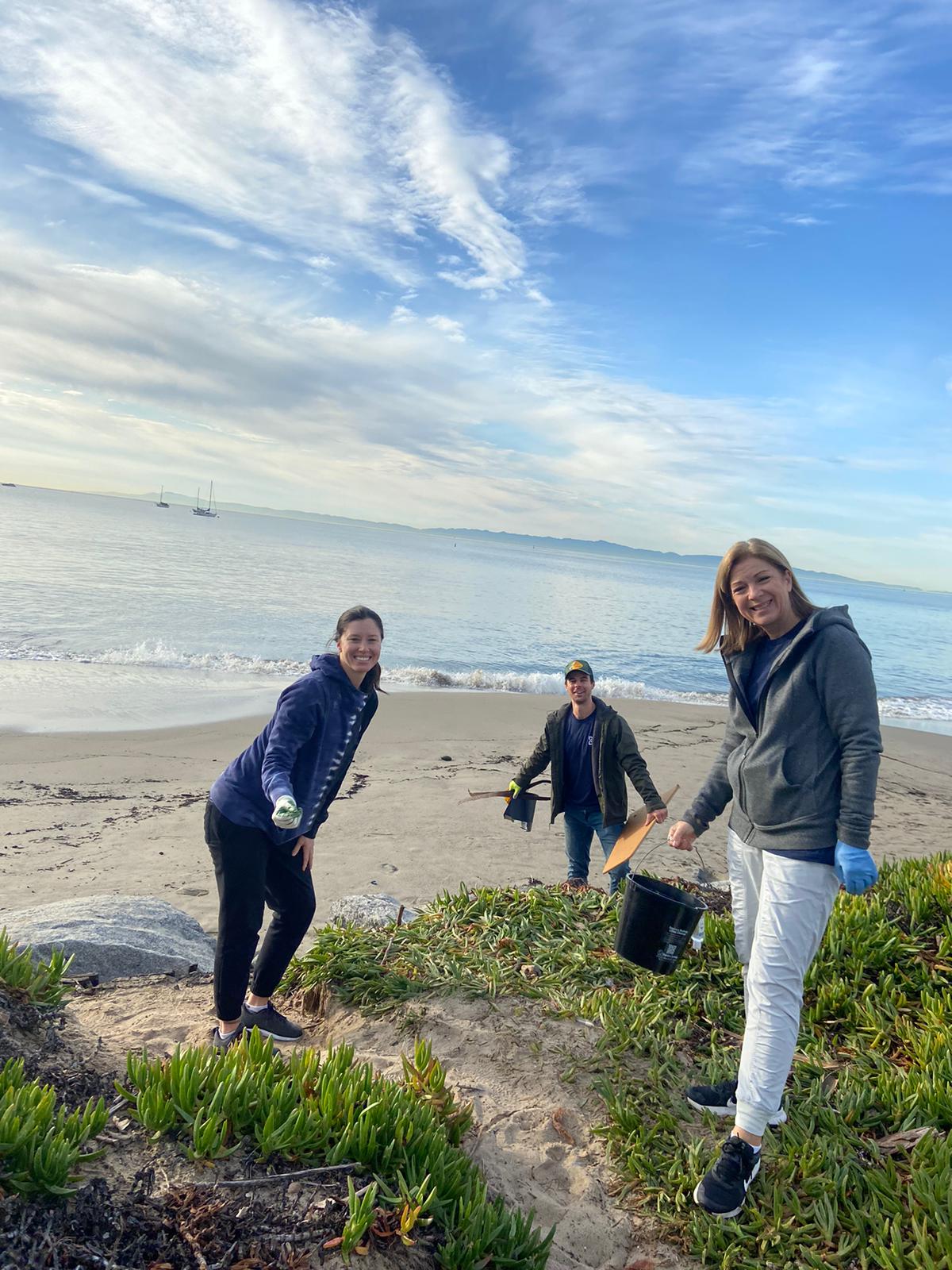Nicole Madosik collects litter with Mission Wealth colleagues during a beach cleanup.
