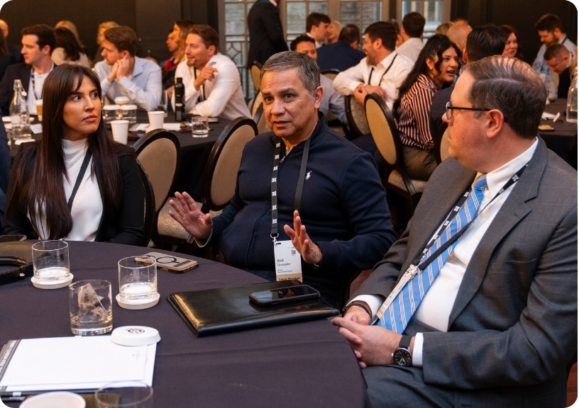 A diverse group engages in conversation at a round table during a networking event.