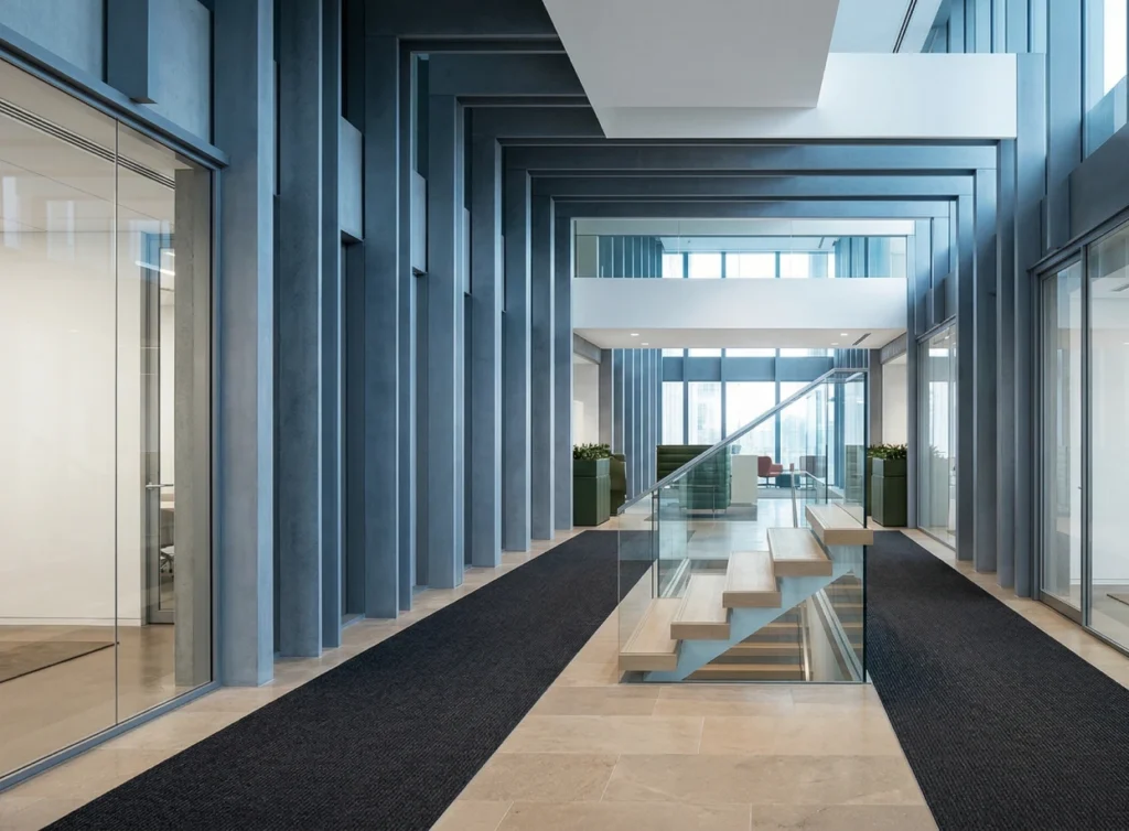 Modern office interior with glass walls and an open staircase