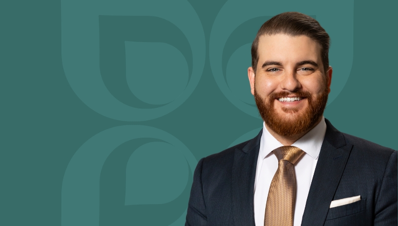 Smiling professional in a suit, representing Mission Wealth's portfolio modeling services for clients.