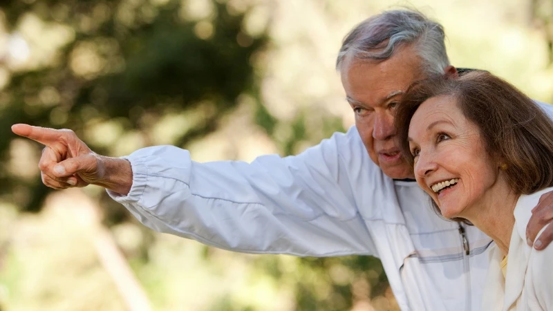 Elderly couple enjoying a moment together outdoors, discussing future plans and reflecting on life experiences.