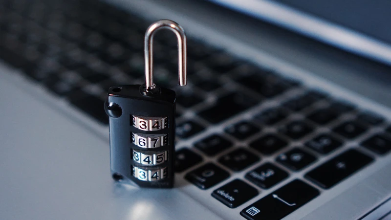 A combination padlock rests on a laptop keyboard, symbolizing account security and protection.