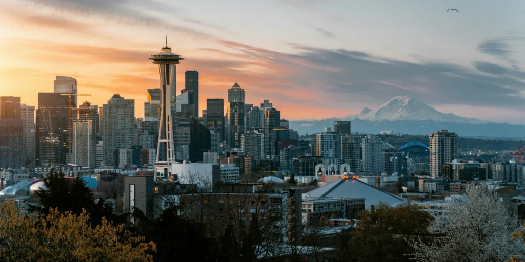 Seattle skyline at sunset featuring the Space Needle and Mount Rainier in the background, highlighting urban planning context.