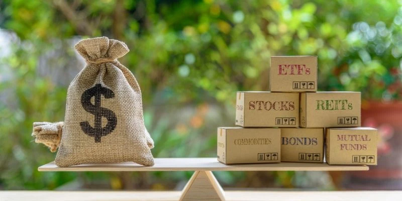 A burlap money bag balances with labeled boxes representing various investment types on a wooden scale.