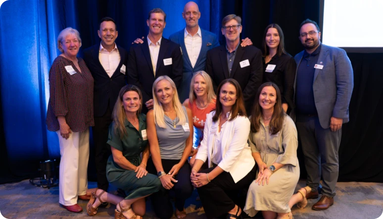 A diverse group of professionals poses together at a networking event, showcasing camaraderie and collaboration.