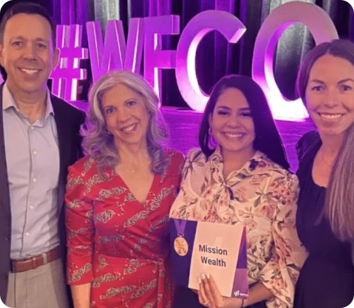 Group of professionals posing together at an event, holding signs with words like "Adaptable" and "Growth Mindset."