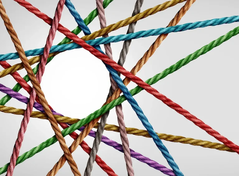 Colorful twisted ropes overlap and intersect against a light background, creating a dynamic and textured visual composition.