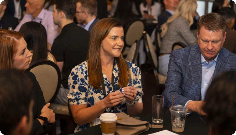 A diverse group of professionals engages in conversation at a round table during a networking event.