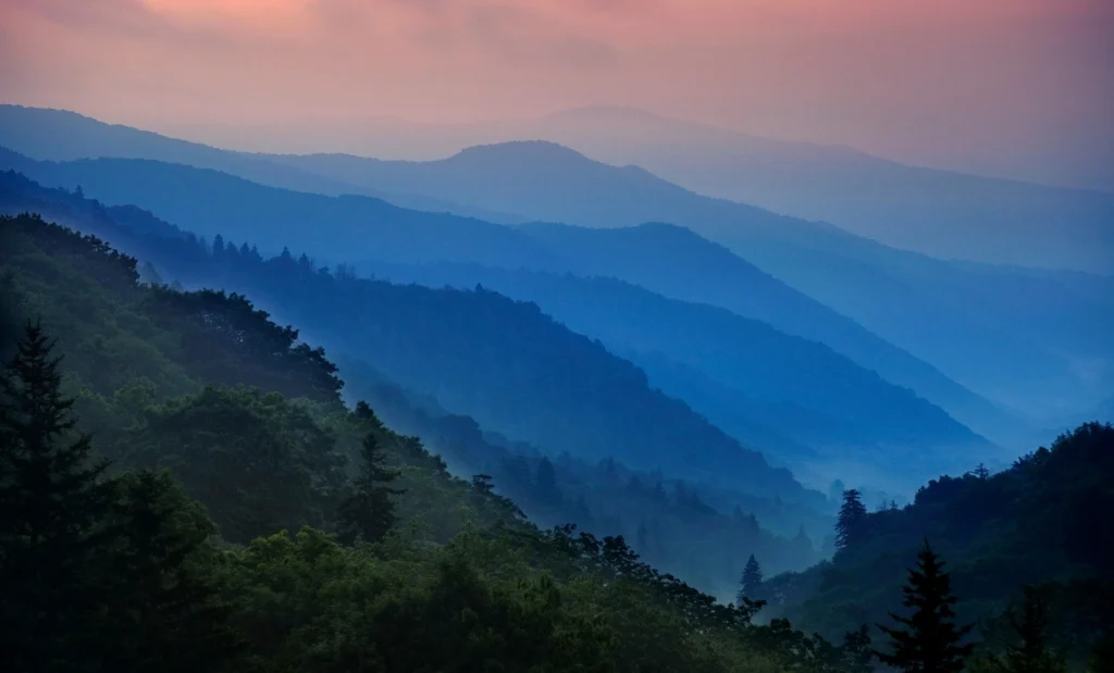 Foggy blue mountain ranges at dawn, symbolizing the serene beauty of nature relevant to estate planning discussions.