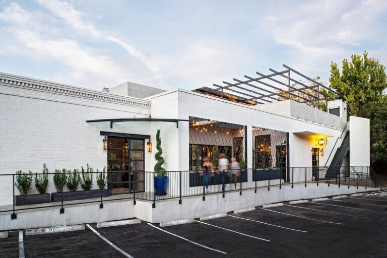 The Eberly features a modern exterior with a welcoming entrance and outdoor seating, surrounded by greenery and parking.